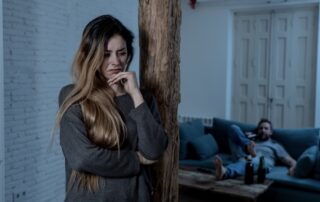 Woman looking upset while partner is drunk on the sofa